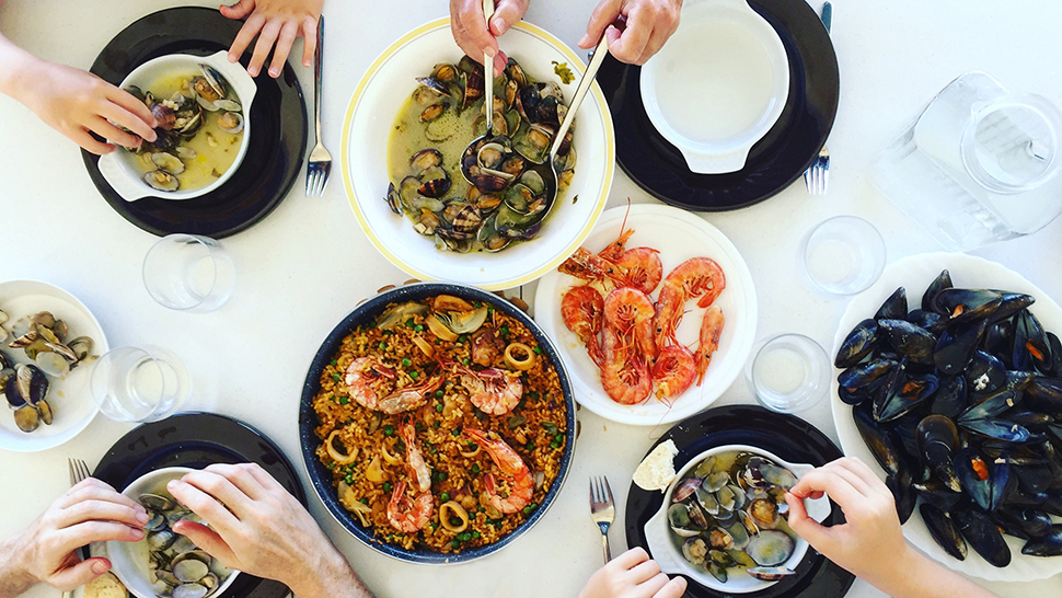 Family eating Paella and seafood. Top view.