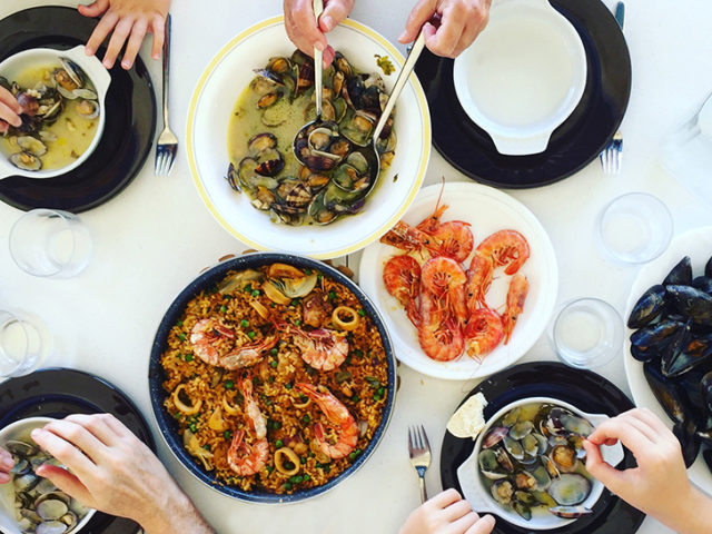 Family eating Paella and seafood. Top view.