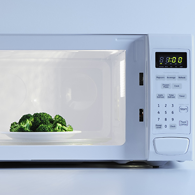 A small plate of broccoli inside a microwave