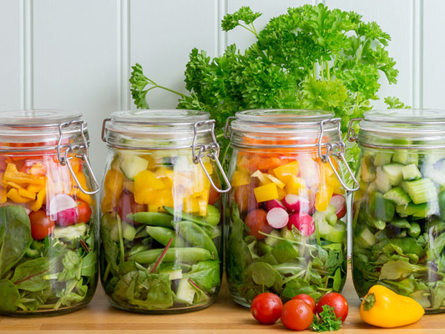 Salad in glass storage jars. Four in a neat row.