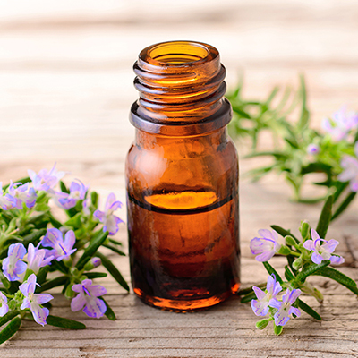Rosemary massage oil and flowers on the wooden table