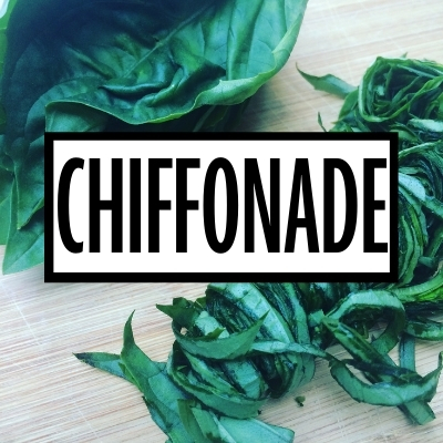 chiffonade cut basil on a table with a white graphic with the word "chiffonade" in black writing