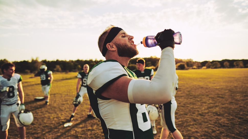 a football player drinking water from a bottle