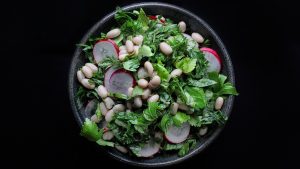 Salad made with celery leaves, beans, and radishes promotes whole-plant, low-waste eating.