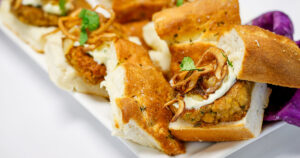 Plant-based sliders made with chickpeas, piled high with crispy onions and creamy goodness.