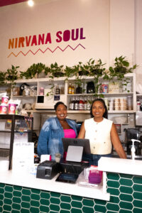 Owners of Nirvana Soul, Jeronica Macey and Be’Anka Ashaolu, standing behind the register at their shop.