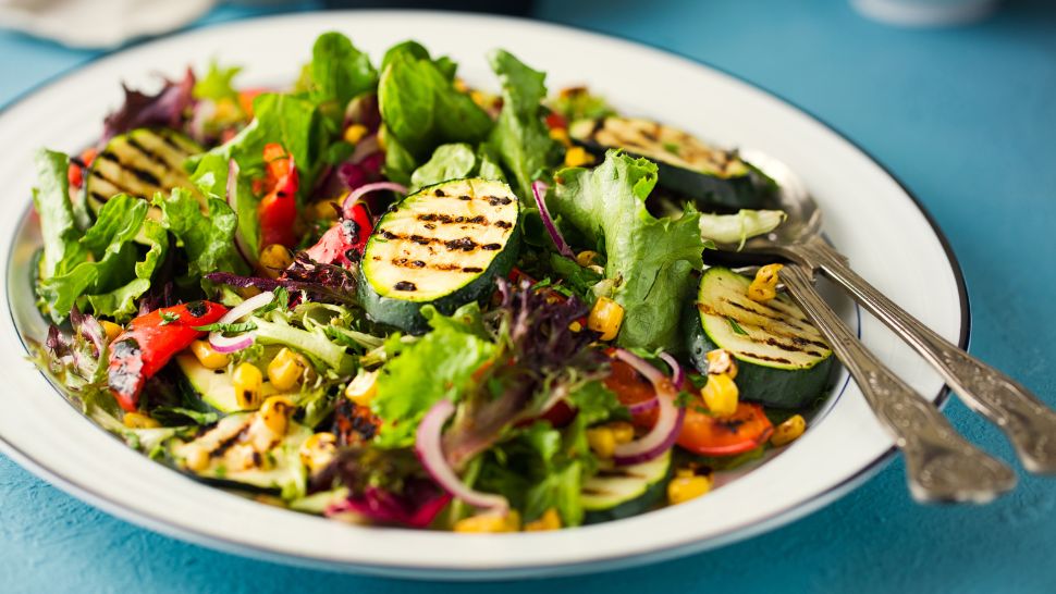 Charred zucchini and colorful vegetables tossed with greens in a summery grilled salad.