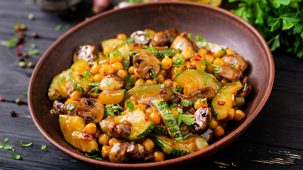 Hearty vegetable and chickpea stir-fry in a clay bowl.